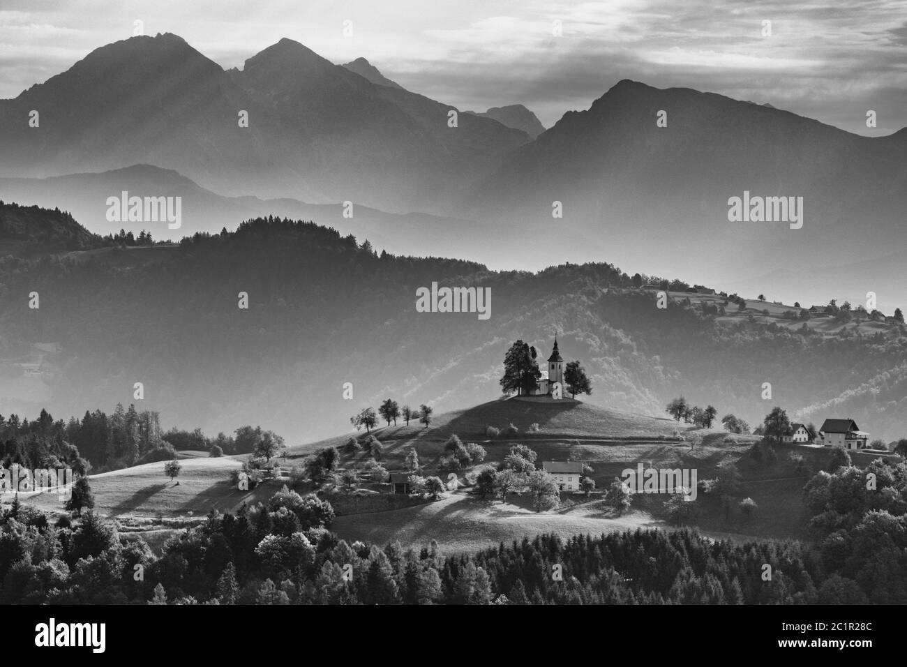 St. Thomas Kirche unter den Bergen, schwarz-weiß Foto der Kapelle auf dem Hügel, Slowenien Stockfoto