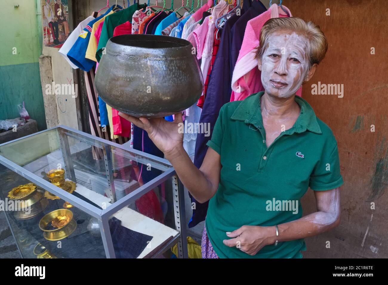 Eine Frau in Baan Baat, Bangkok, Thailand, mit Talkumpuder bedeckt, zeigt eine der Almosenschalen der Mönche (baat), die traditionell in Baan Baat hergestellt werden Stockfoto