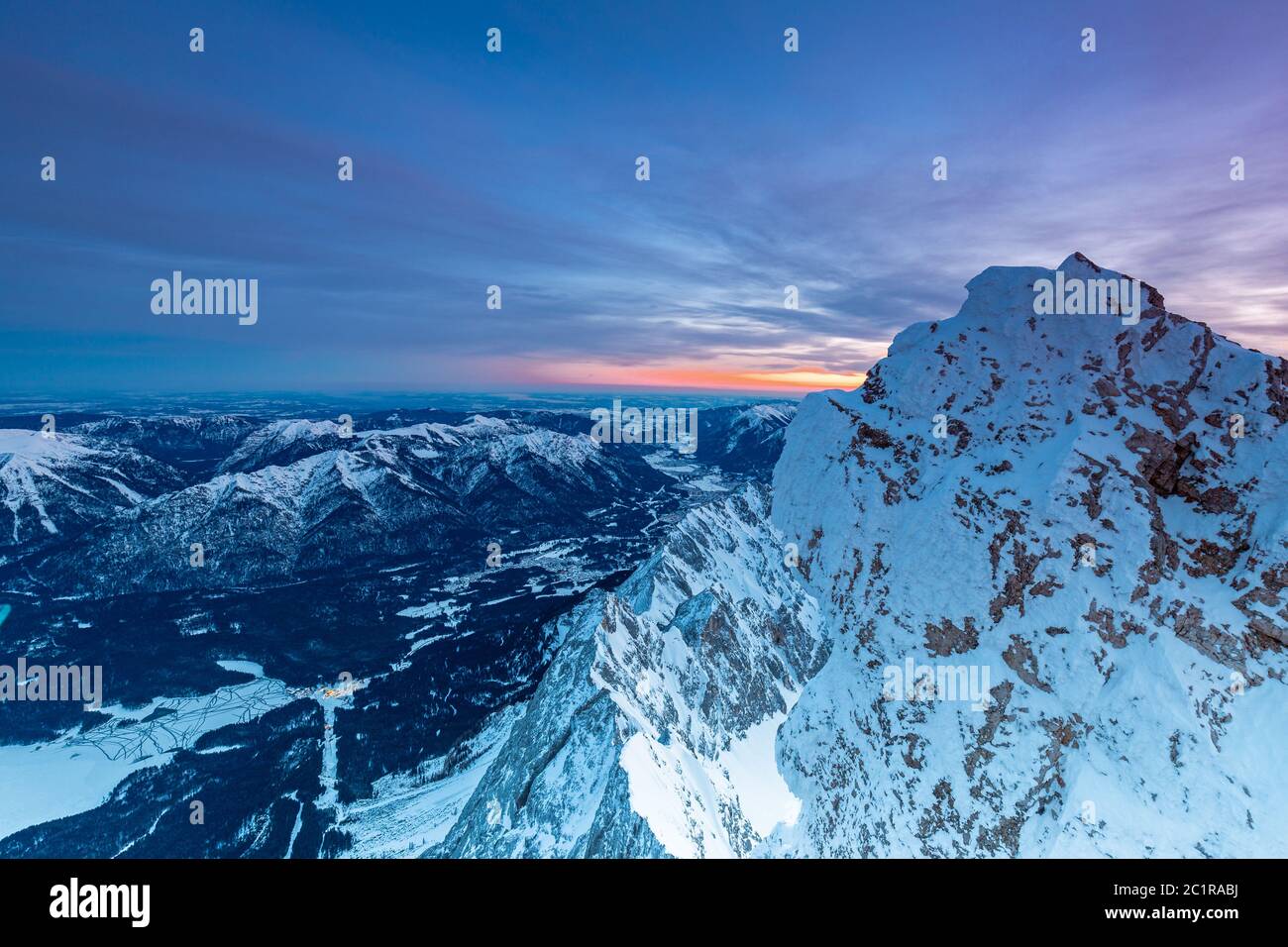 Tagesanbruch auf der Zugspitze Gipfel mit Blick auf Garmisch Partenkirchen und Loisach river valley beleuchtet Stockfoto