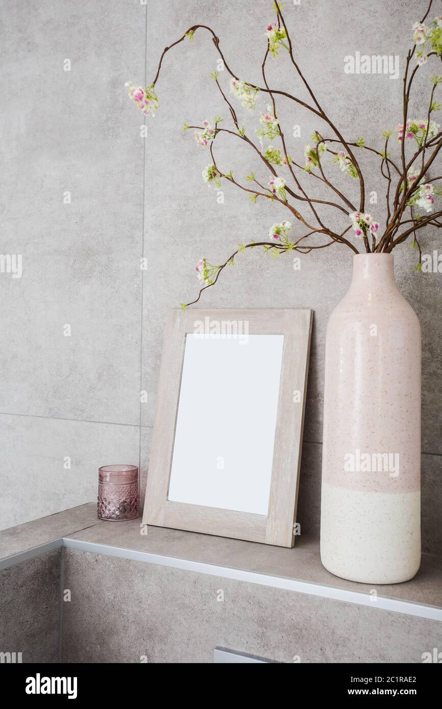 Home Decor, neutral Vasen mit leeren Rahmen gegen graue Wand moderne Dekoration Stockfoto