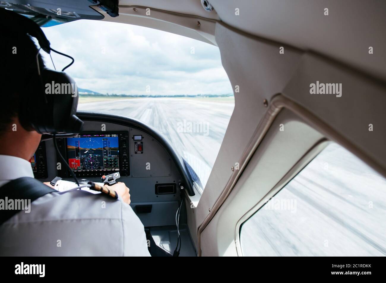 Pilot Steuerflugzeug mit Joystick im Pilot Cockpit während eines Fluges mit kleinen Verkehrsflugzeug. Start mit Start-und Landebahn-Szene. Stockfoto