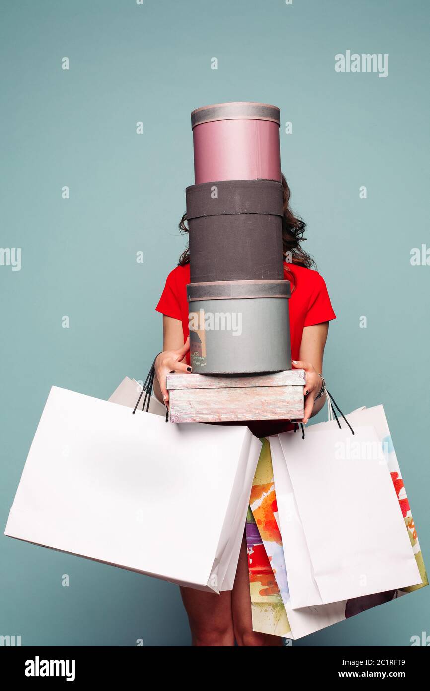 Incognito Brünette hält an Händen Taschen und Boxen nach dem Einkaufen. Stockfoto