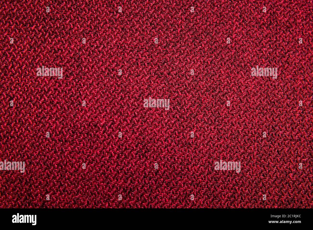 Texturierte Hintergrundfläche von textilen Polstermöbeln Nahaufnahme. Rot Farbe Stoff Struktur Stockfoto