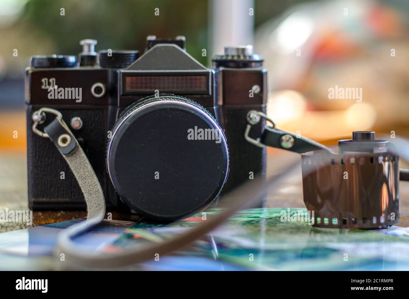 Alte Fotorolle und Retro-Kamera auf dem Schreibtisch Stockfoto