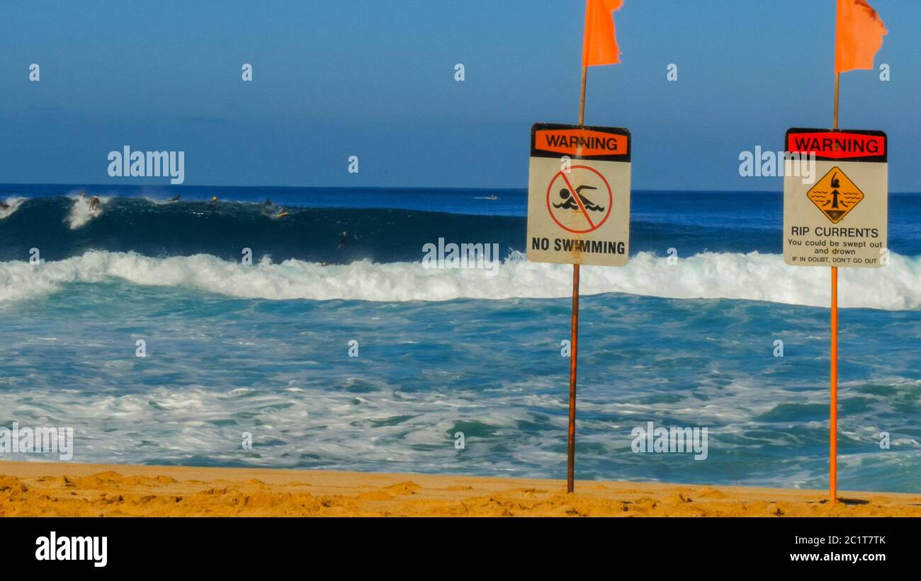 Gefährliche Surfbedingungen und ein No-Swimming-Schild am Strand Stockfoto