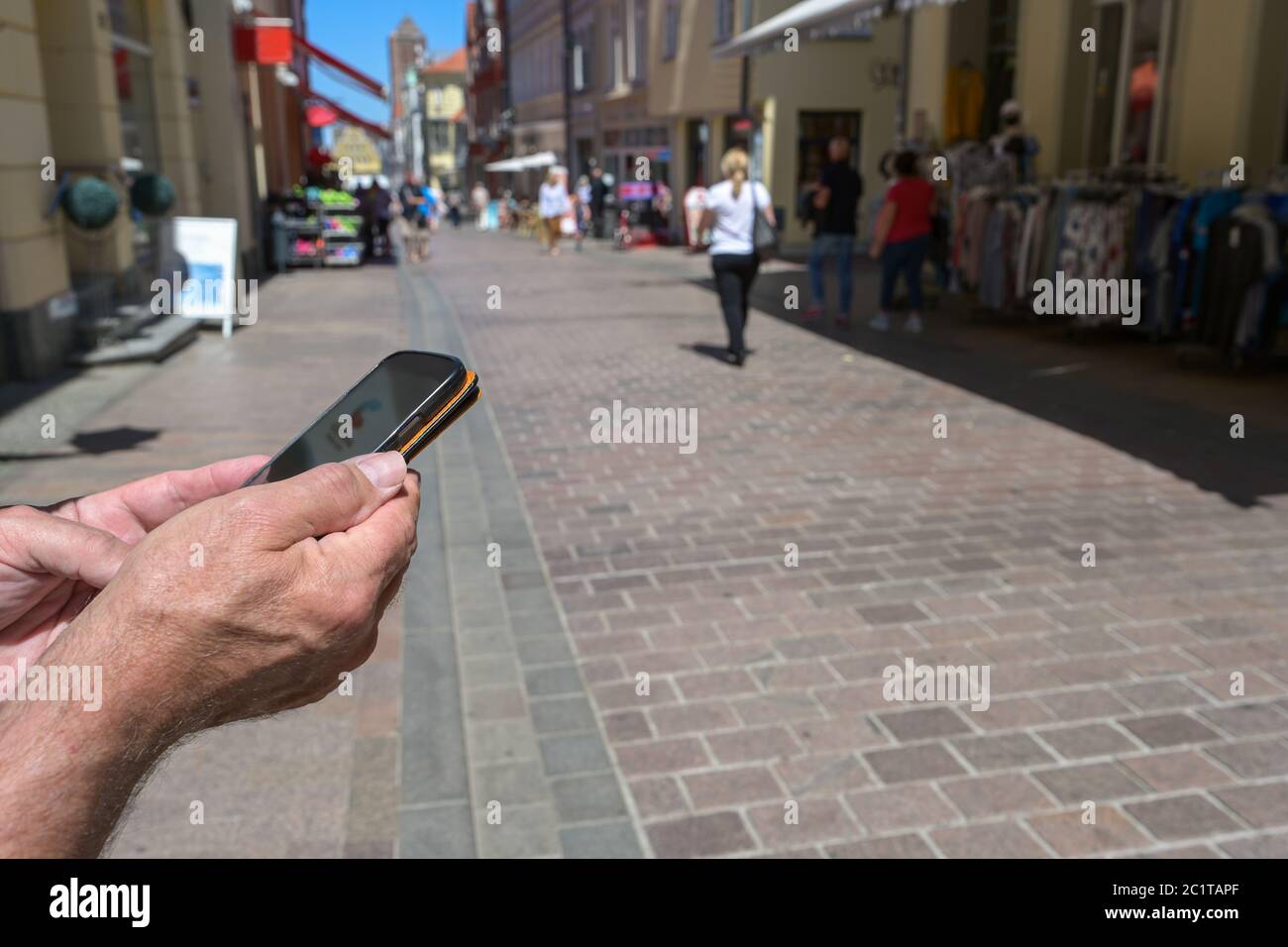Hände halten ein Smartphone mit einer Kontaktverfolgungs-App gegen Coronavirus und Covid 19 Pandemie, eine deutsche Corona-Warn-Anwendung, um andere zu verbinden Stockfoto