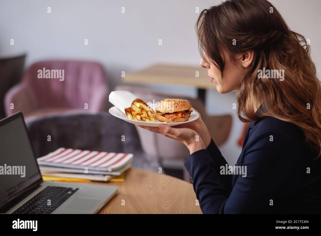 Frau im Profil mit Teller mit Lebensmitteln in den Händen Stockfoto