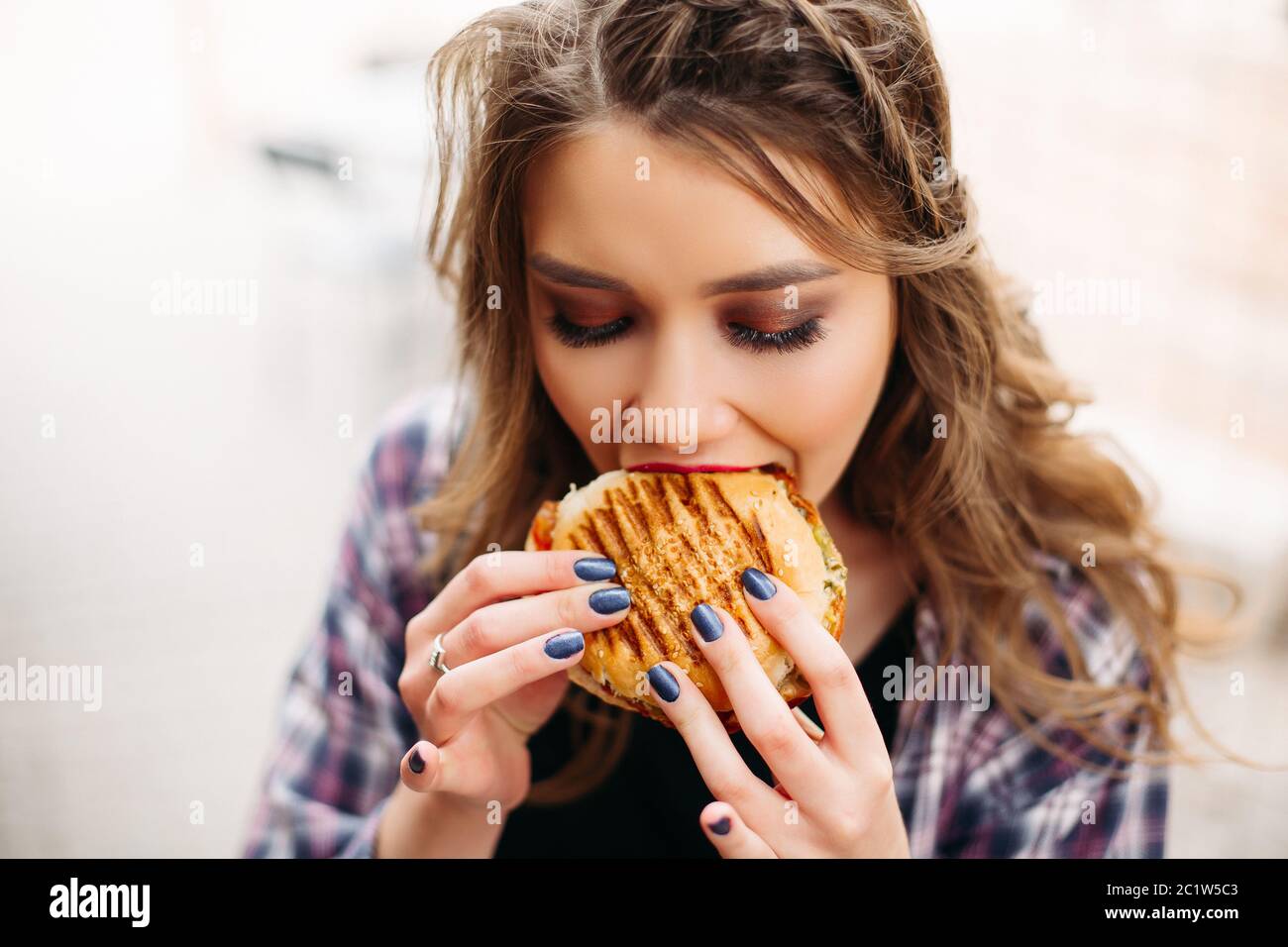 Foodie mit Hamburger beiseite, mit entsetzten Ausdruck. Stockfoto