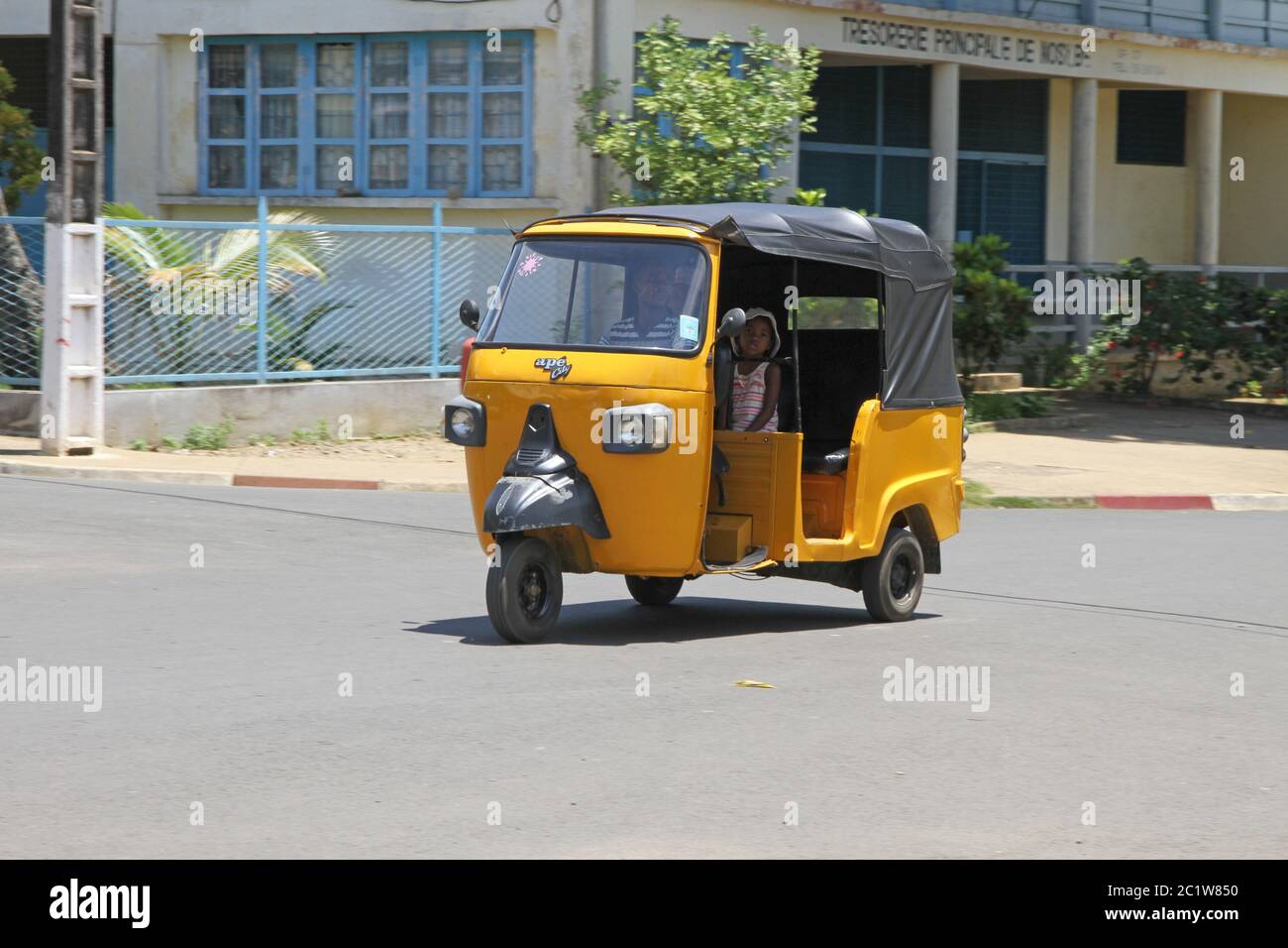 Tuk-Tuk Taxi auf der Straße vor dem Staatsschatz, Andoany/Hell-Ville City, Madagaskar. Stockfoto