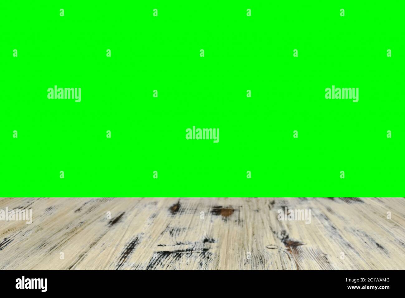 Alt bemalter gewaschene Eichenholztisch auf dem verschwommenen Chroma-Schlüssel grünen Bildschirm Wand Hintergrund, Holztisch. Stockfoto