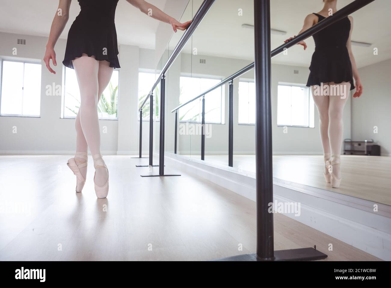 Kaukasische Balletttänzerin, die sich auf ihre Übung in einem hellen Studio konzentriert Stockfoto