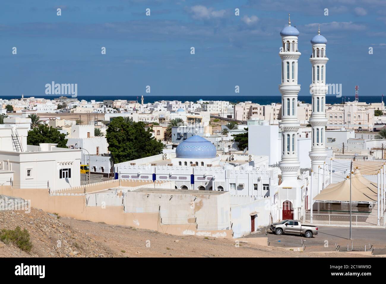 Blick über die Stadt Sur im Oman auf das Meer mit seinen weißen Gebäuden und Minaretten Stockfoto