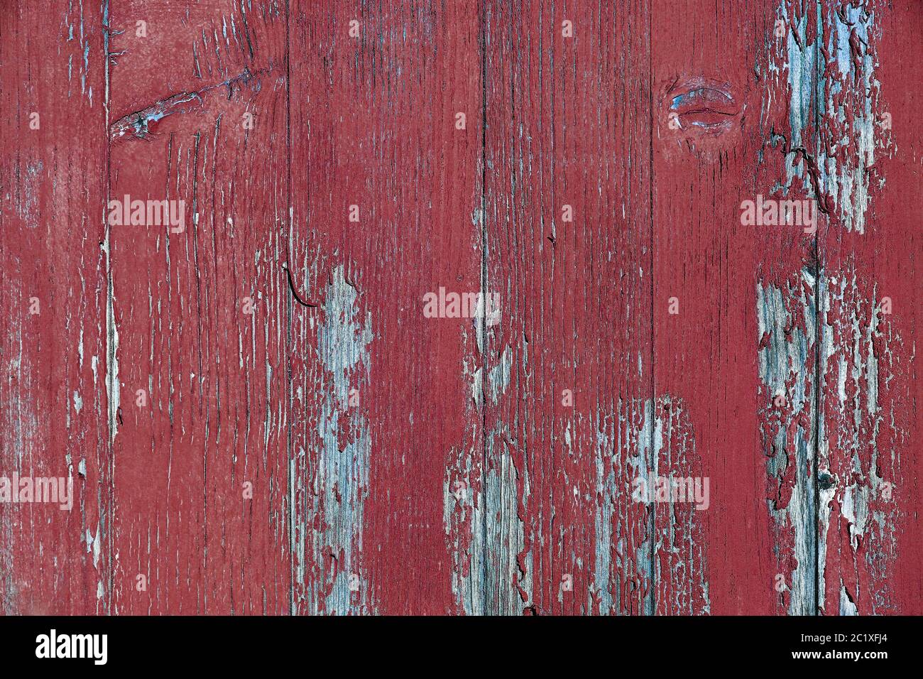 Eine kaputte Holzwand mit alter roter Farbe Stockfoto