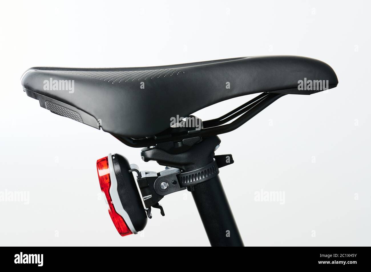 Fahrradsitz aus schwarzem Leder mit roter Rückleuchte isoliert Stockfoto