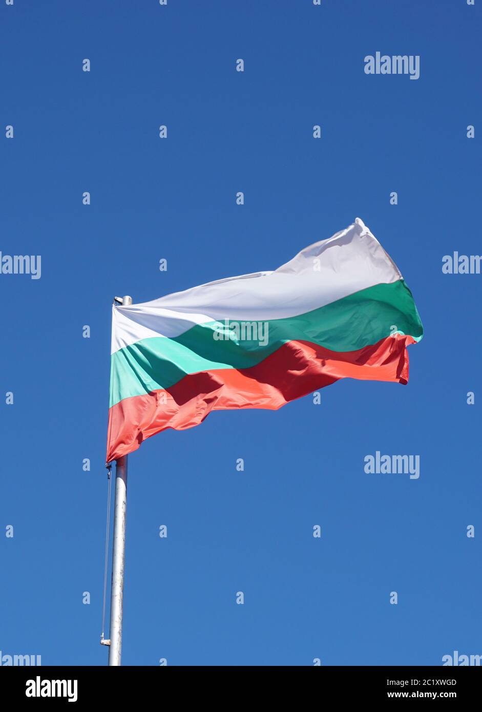 Bulgarische Flagge winkt im Wind und Sonnenlicht, und ein blauer Himmel. Stockfoto