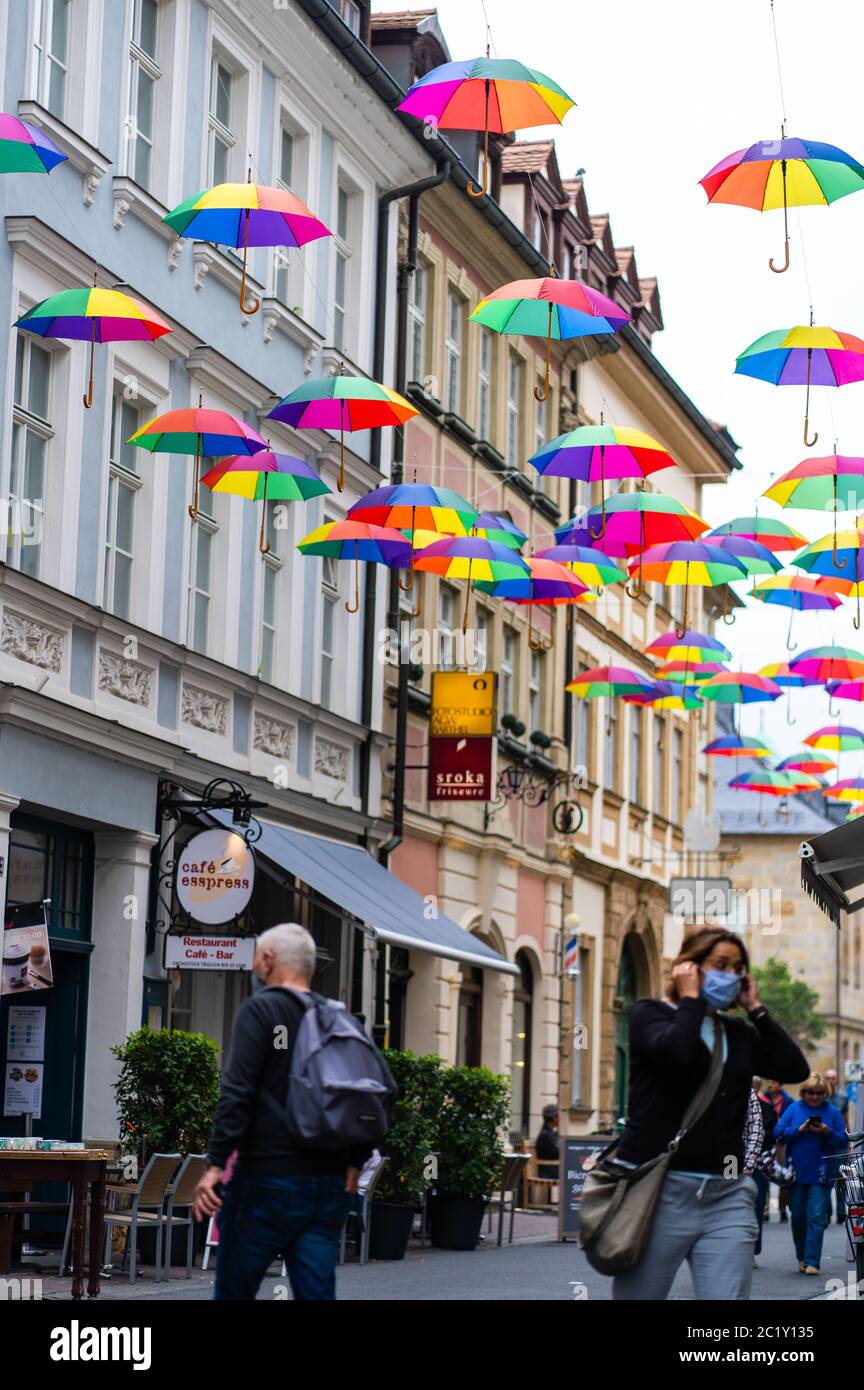 Bamberg, Deutschland. Juni 2020. Bunte Regenschirme hängen über der Straße  in der Bamberger Altstadt. Mit bunten Schirmen wollen Gastronomen und  Friseure in der Austraße in Bamberg ein Beispiel in der Coronakrise setzen,