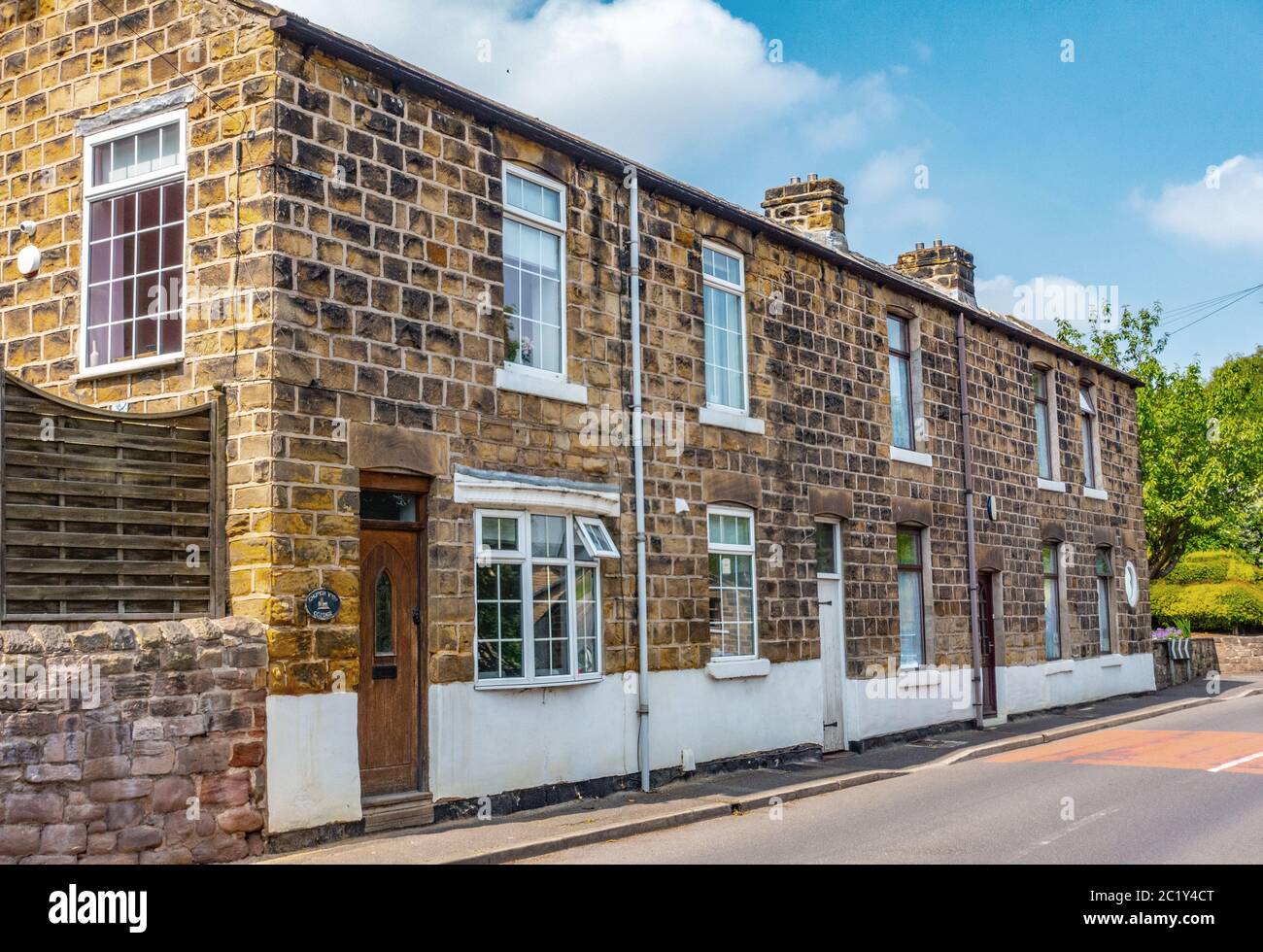Rundes Cottage Fenster auf Steinhauswand Stockfoto