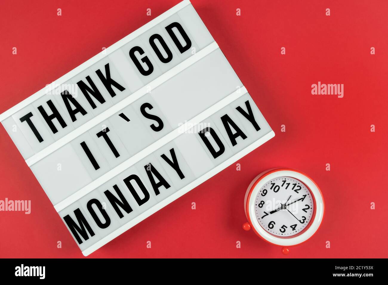 Text GOTT SEI DANK IST ES MONTAG TAG auf Leuchtkasten auf rotem Hintergrund mit Wecker. Stockfoto