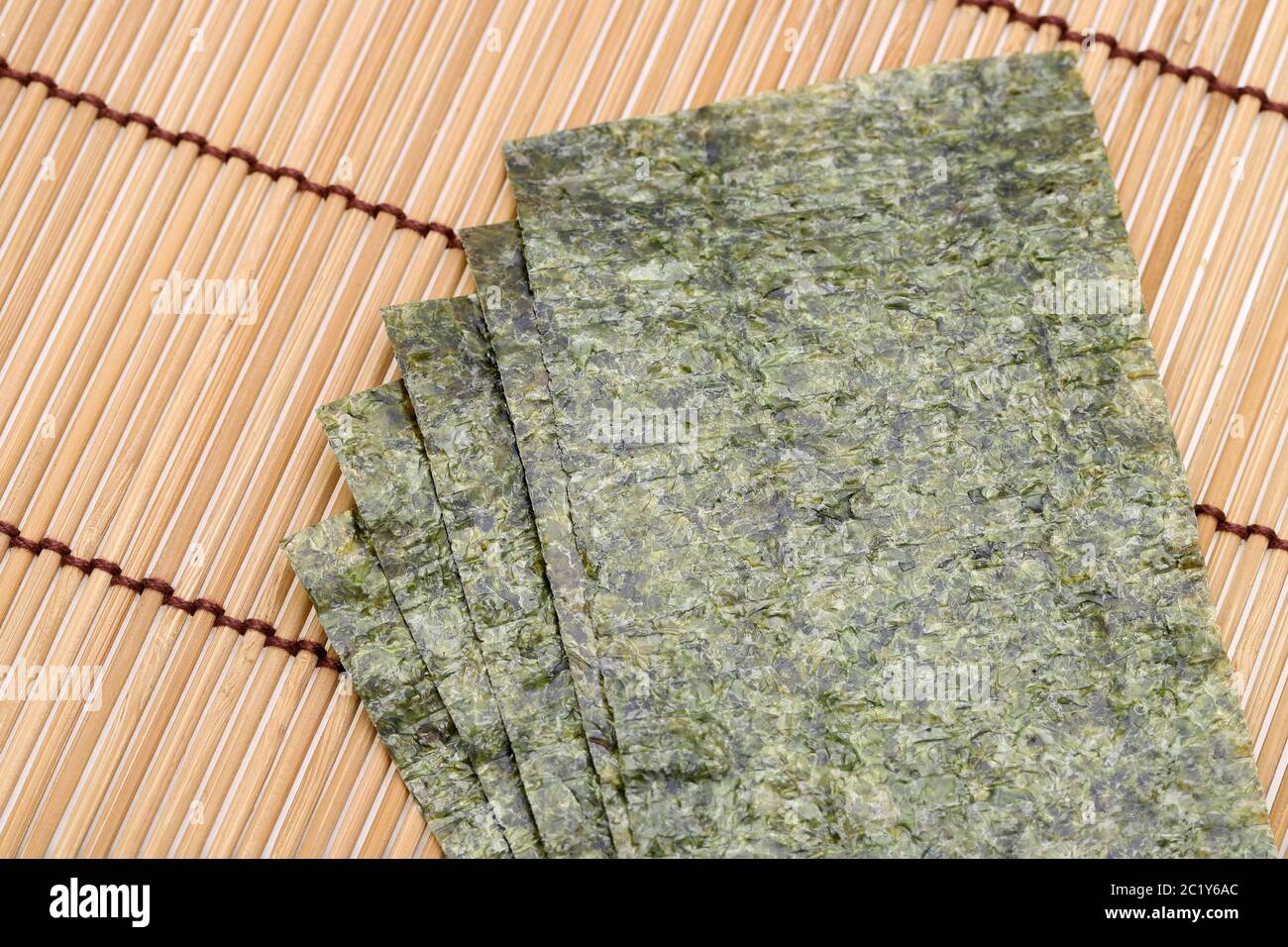 Japanisches Essen, trockene Algenblätter von Nori auf Bambusgrund Stockfoto