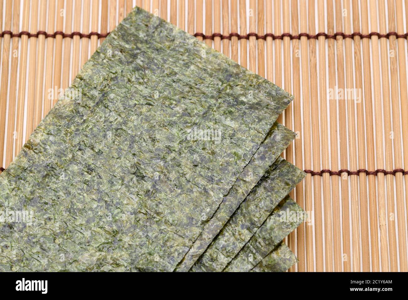 Japanisches Essen, trockene Algenblätter von Nori auf Bambusgrund Stockfoto