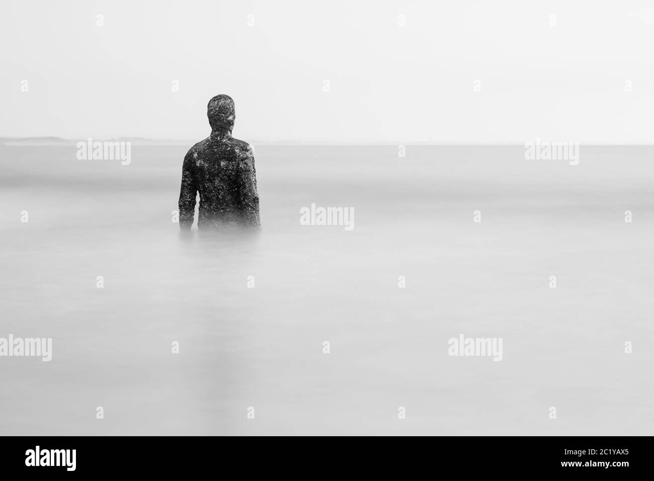 Eine Iron man Statue Taille tauchen im Wasser bei Flut an der Küste bei Liverpool (England) im Juni 2020 gesehen. Stockfoto