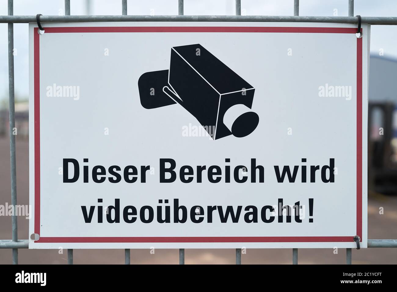 Schild mit der Aufschrift "Dieser Bereich wird Video zu einem Zaun überwacht" in Deutschland Stockfoto