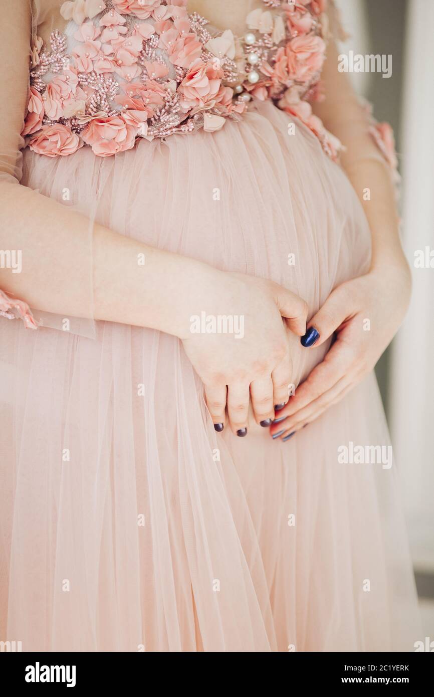 In der Nähe der schwangeren Frau in Pulver langes Kleid Bauch berühren. Stockfoto