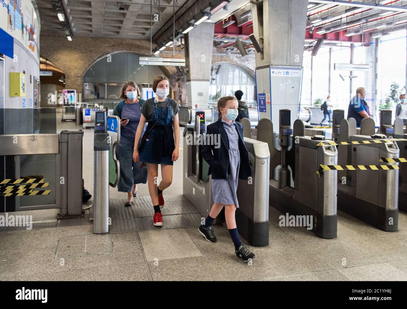 Kinder tragen Gesichtsmasken in öffentlichen Verkehrsmitteln. Ticketbarrieren, U-Bahnstation Waterloo. London, Großbritannien. Juni 2020. EINWILLIGUNGSFORMULARE UNTERZEICHNET FO Stockfoto