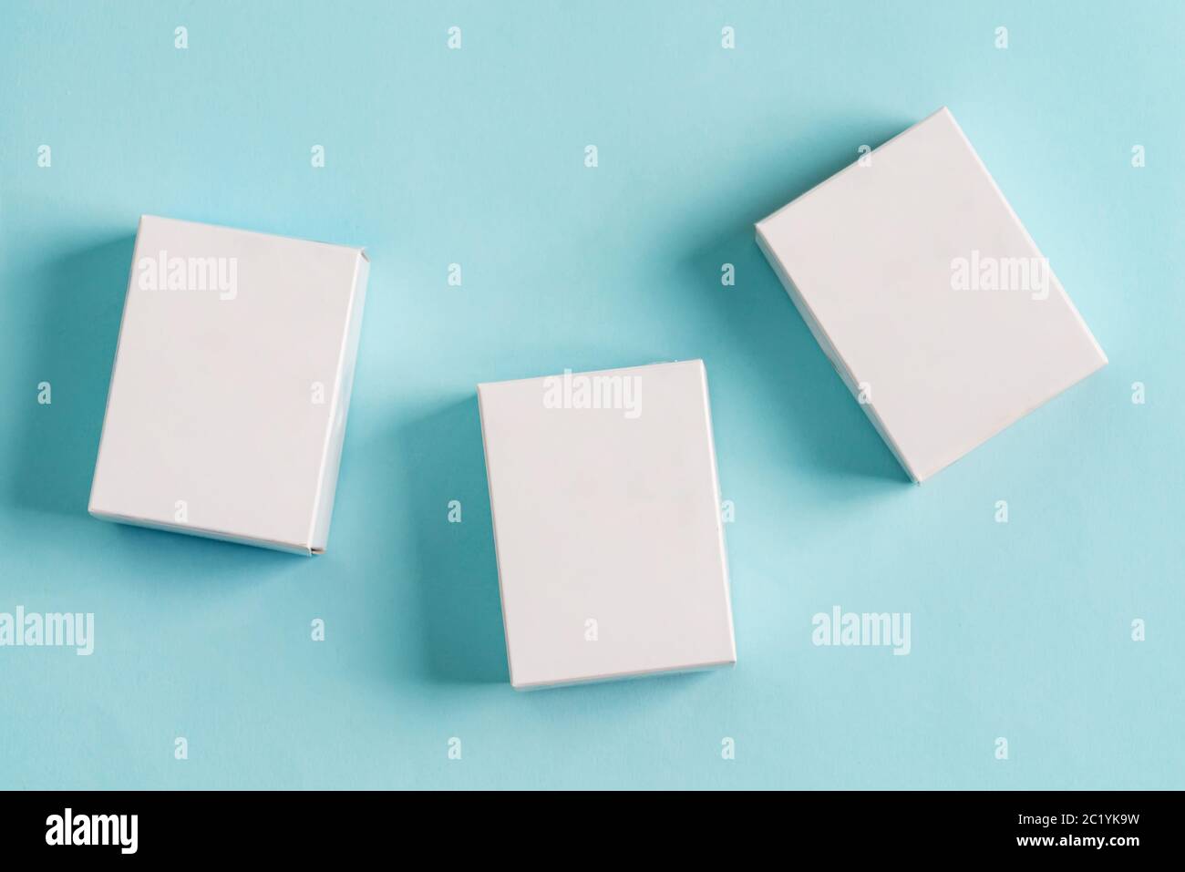 Set aus drei Papier-Mock-up-Boxen für Verpackungen von Produkten und Dingen auf einem pastellblauen Hintergrund. Stockfoto
