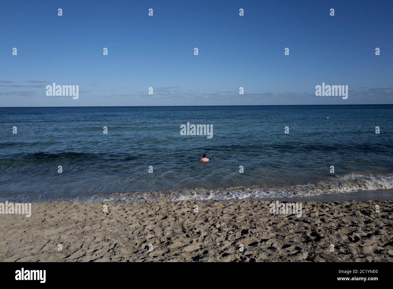 Einsamer Mann, der am ersten Tag des Jahres, an einem sonnigen Wintertag, in Palermo badete. Stockfoto