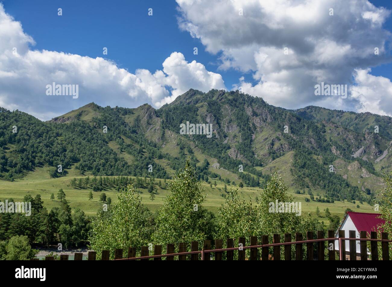 Kleine Häuser zwischen grünen Bergen und Himmel mit blauen Wolken Stockfoto