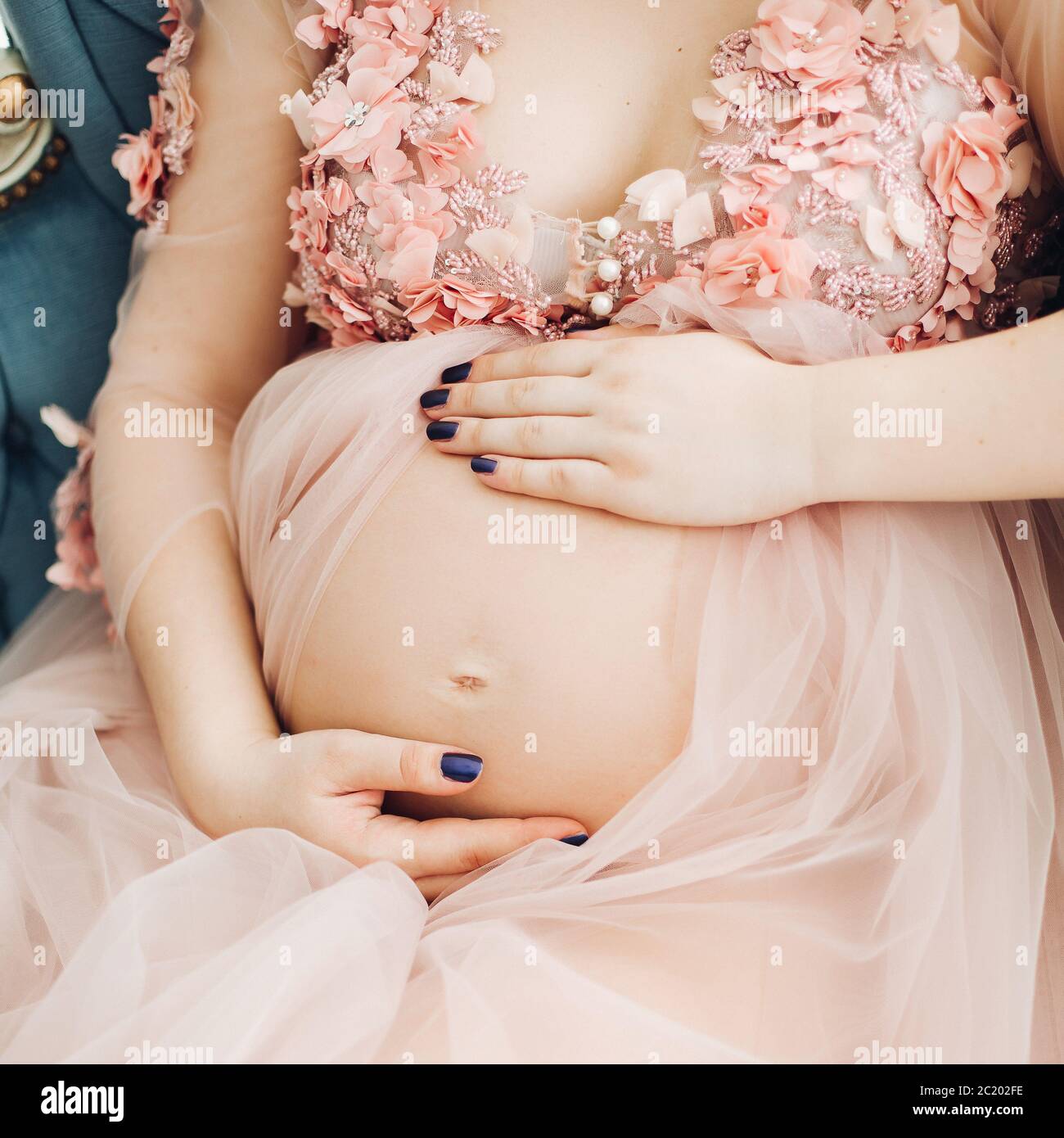 Schöne schwangere Frau, Hände auf Bauch am Herzen. Stockfoto