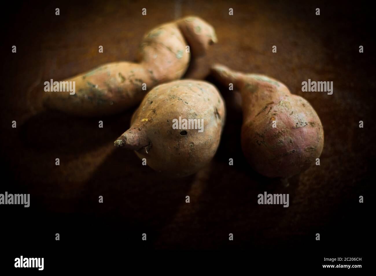 Rohe Süßkartoffeln auf einem Holztisch, topview Stockfoto