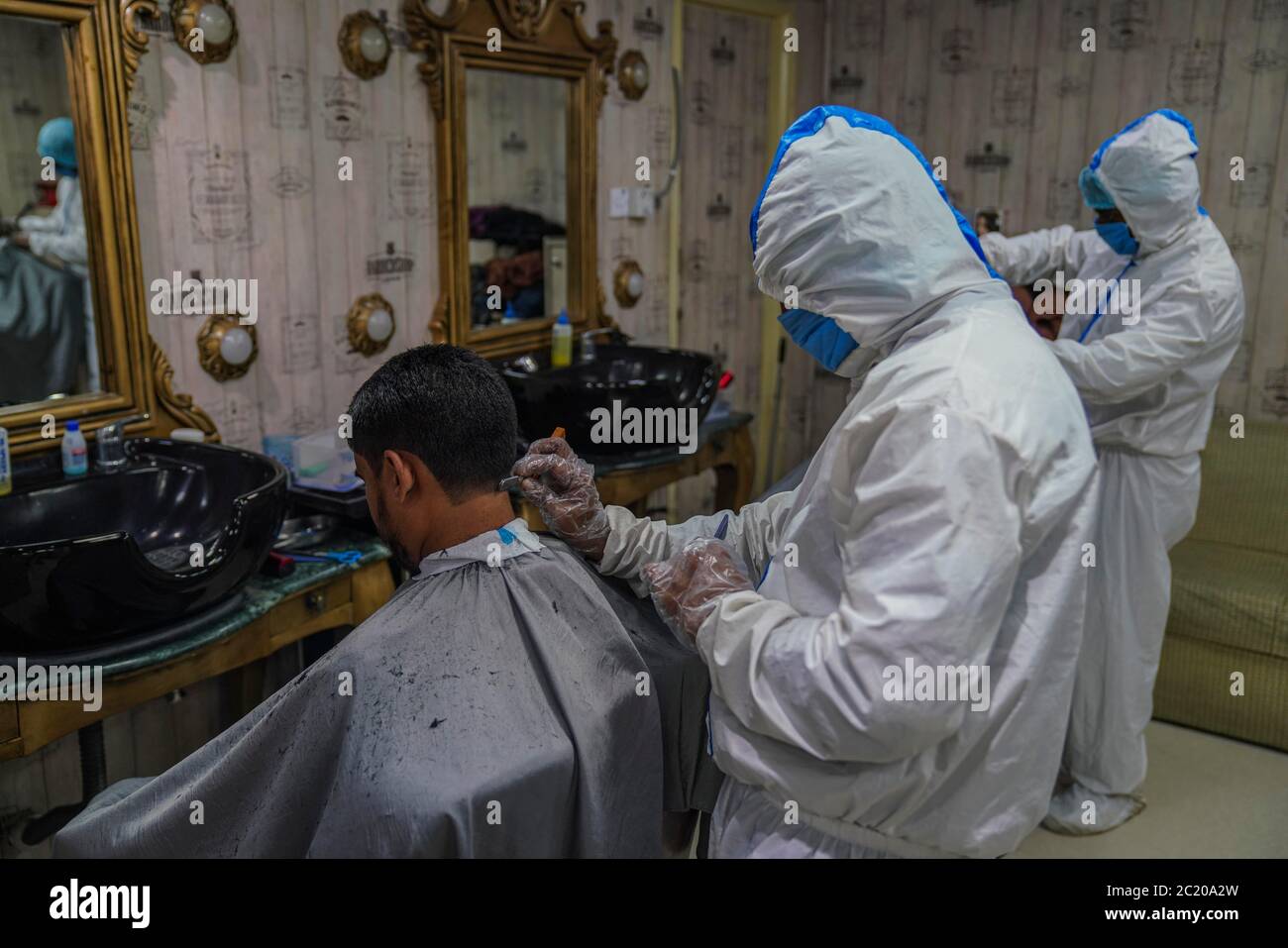 Dhaka, Dhaka, Bangladesch. Juni 2020. Barbiere in Schutzanzügen und Gesichtsmasken bieten dem Kunden während der COVID-19-Coronavirus-Pandemie am 16. Juni 2020 in Dhaka, Bangladesch, einen Haarschnitt-Service in einem Salon. Kredit: Zabed Hasnain Chowdhury/ZUMA Wire/Alamy Live Nachrichten Stockfoto