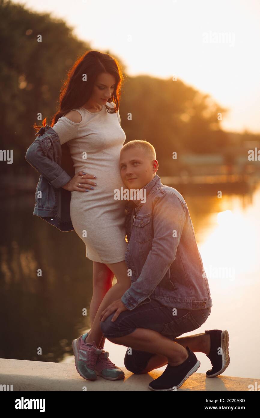 Lächelnd glückliche Menschen hören auf seine Frau Bauch warten auf Baby. Stockfoto