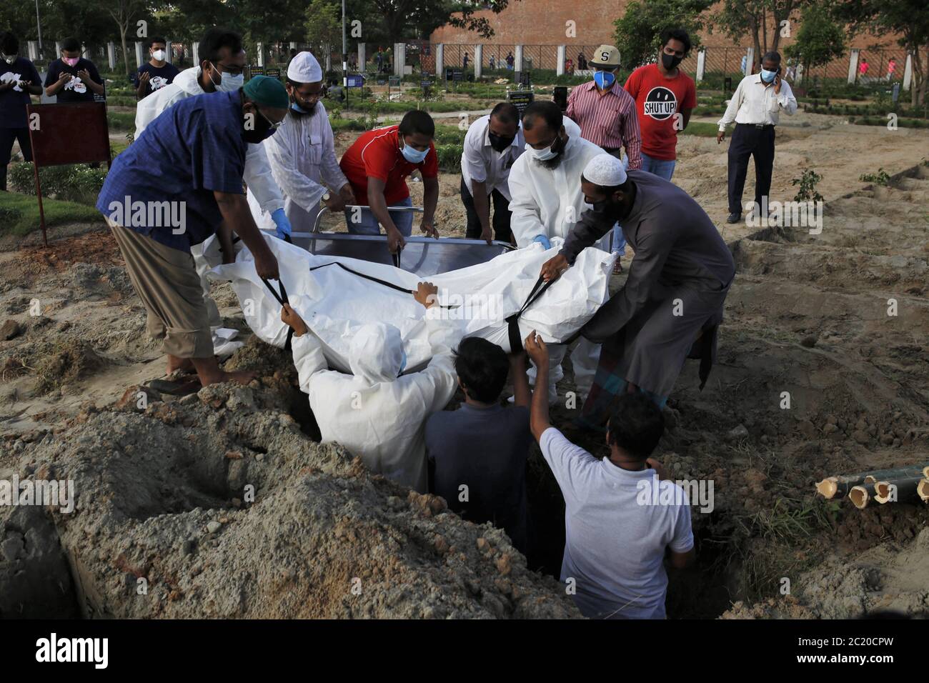 Dhaka, Bangladesch. Juni 2020. Familienmitglieder einer Person, die an einem Coronavirus gestorben ist, bereiten sich darauf vor, den Körper auf dem Friedhof von Rayer Bazar in Dhaka in ein Grab zu senken. Kredit: MD Mehedi Hasan/ZUMA Wire/Alamy Live Nachrichten Stockfoto