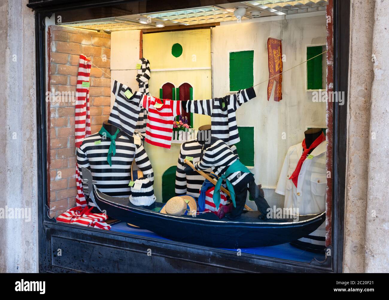 Catering für Touristen und möglicherweise Einheimische Gondolier Kostüme / Outfits einschließlich Stripptrikots und T-Shirts in einem Bekleidungsgeschäft Fenster Venedig Italien Stockfoto