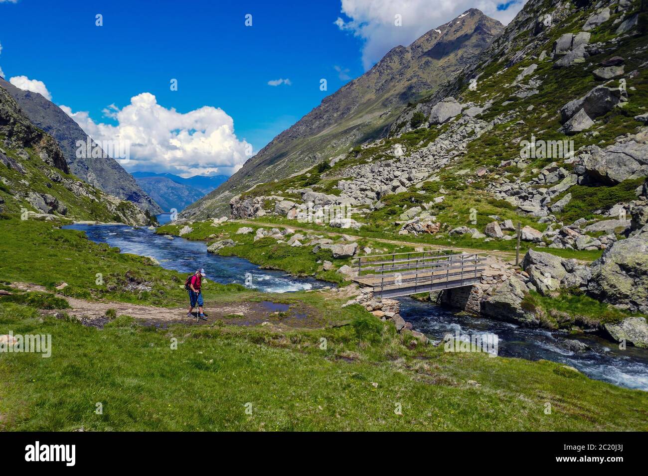 Einsame weibliche Wanderer mit Bach mit Kaskaden fließt durch das Soulcem Tal in den französischen Pyrenäen, Ariege Region, Frankreich, Pyrenäen Berge Stockfoto