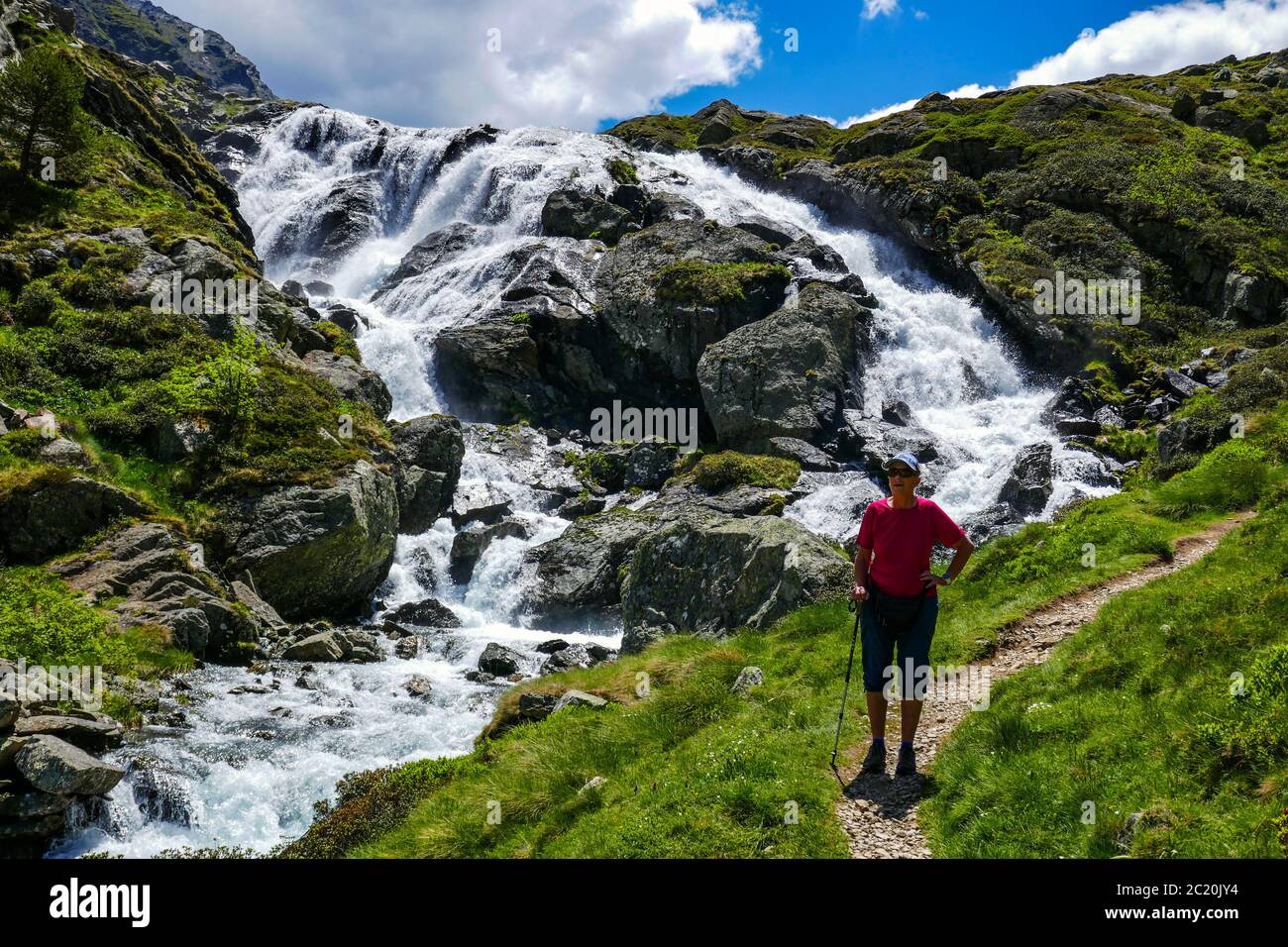 Einsame weibliche Wanderer mit Bach mit Kaskaden fließt durch das Soulcem Tal in den französischen Pyrenäen, Ariege Region, Frankreich, Pyrenäen Berge Stockfoto
