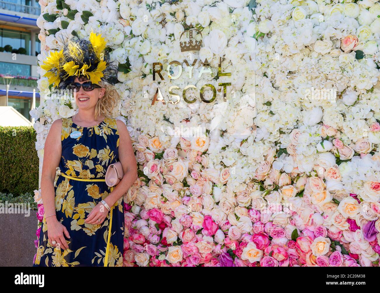 Ascot, Berkshire, Großbritannien. Juni 2018. Eine Dame trägt ein marineblaues und gelbes Kleid und einen passenden Hut, während sie für ein Foto bei Royal Ascot posiert. Quelle: Maureen McLean/Alamy Stockfoto