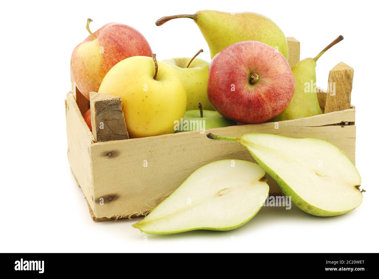 Frisch geerntete Birnen und Äpfel in einer Holzkiste auf weißem Hintergrund Stockfoto