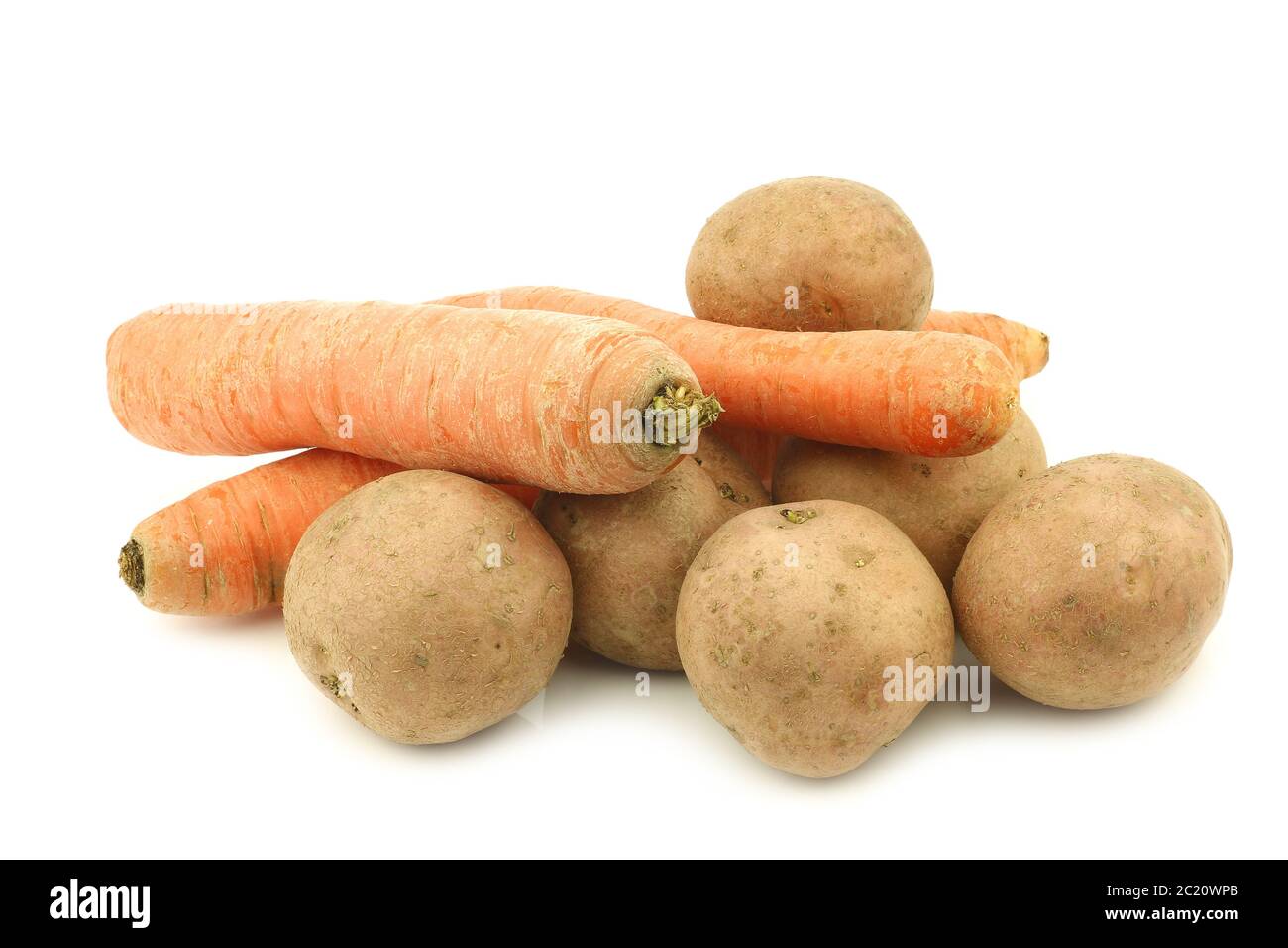 Frisch geerntete Kartoffeln und einige Winterkarotten auf weißem Hintergrund Stockfoto