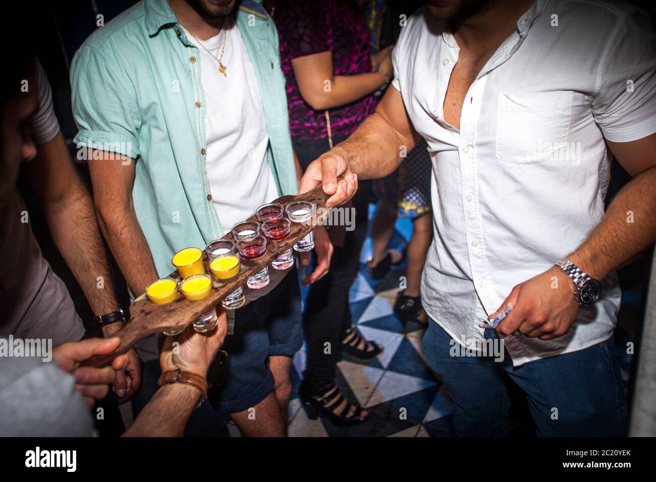 Eine Gruppe männlicher Freunde versammelte sich in einem Nachtclub für alkoholische Getränke Stockfoto