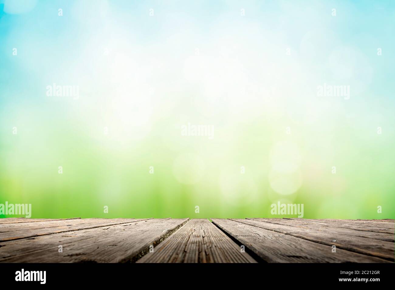 Abstrakt mit sonnigem Wiesenbokeh über Holztisch Stockfoto