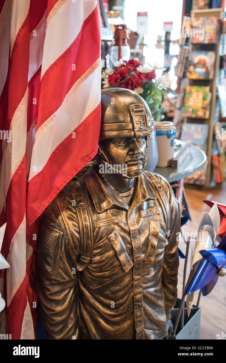 Outdoor-Statue und Fahnenhalter eines US-Soldaten aus Gussstein mit Bronze-Finish zum Verkauf in einem Cracker Barrel Restaurant & Store gebaut Stockfoto