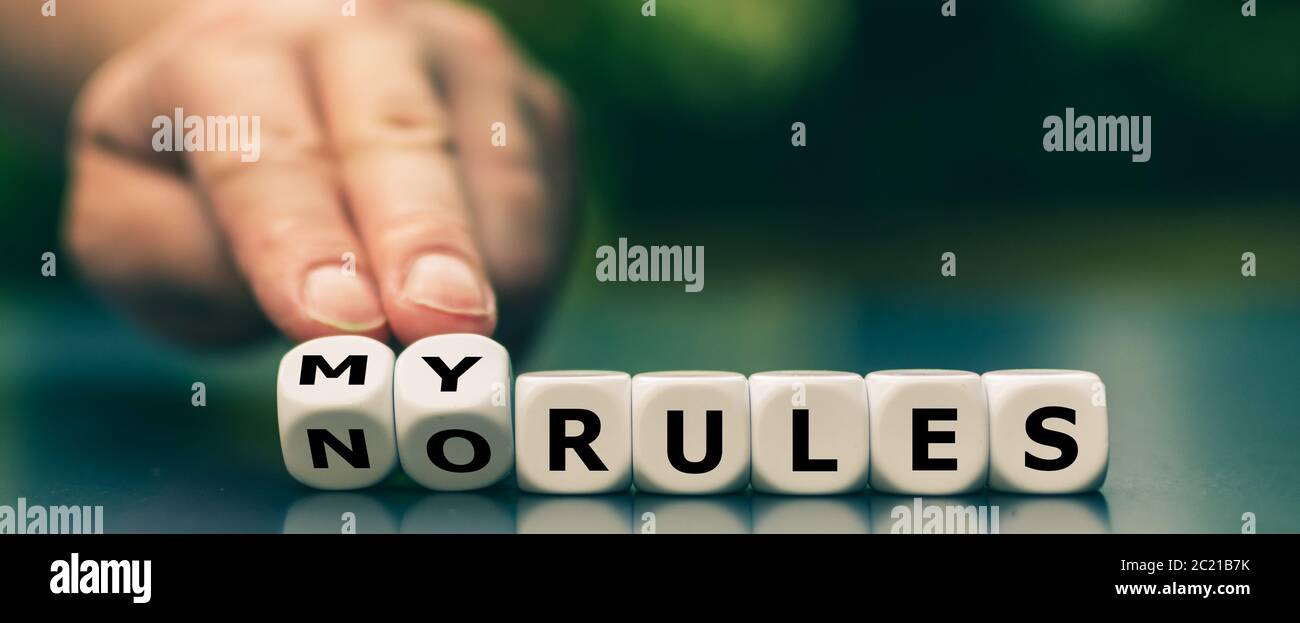 Hand dreht Würfel und ändert den Ausdruck "keine Regeln" in "Meine Regeln". Stockfoto