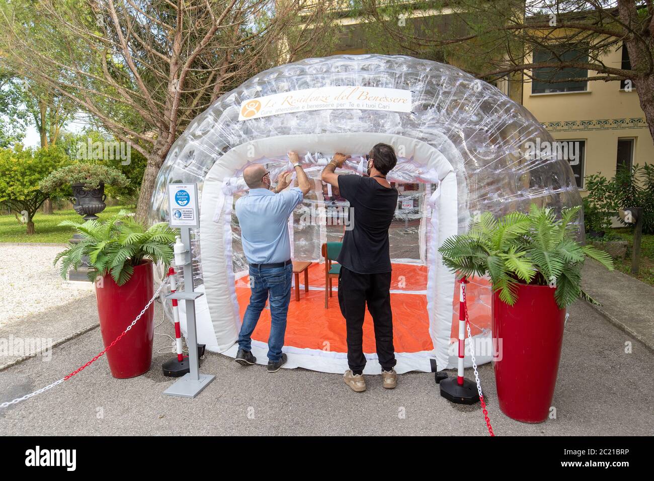 Alte Menschen treffen ihre Verwandten in einem speziellen Iglu-förmigen Sanitärzelt aufgrund der Oronavirus-Pandemie in Migliaro, Italien. Kredit: Filippo Rubin / Alamy Live Nachrichten Stockfoto