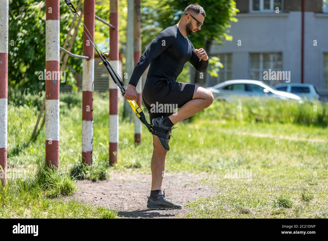 Mann trainiert bauchmuskeln mit Federung Fitness-Gurte im Fitnessstudio. Magen Bauchmuskeln Training gesunde Lebensweise Sport. Stockfoto