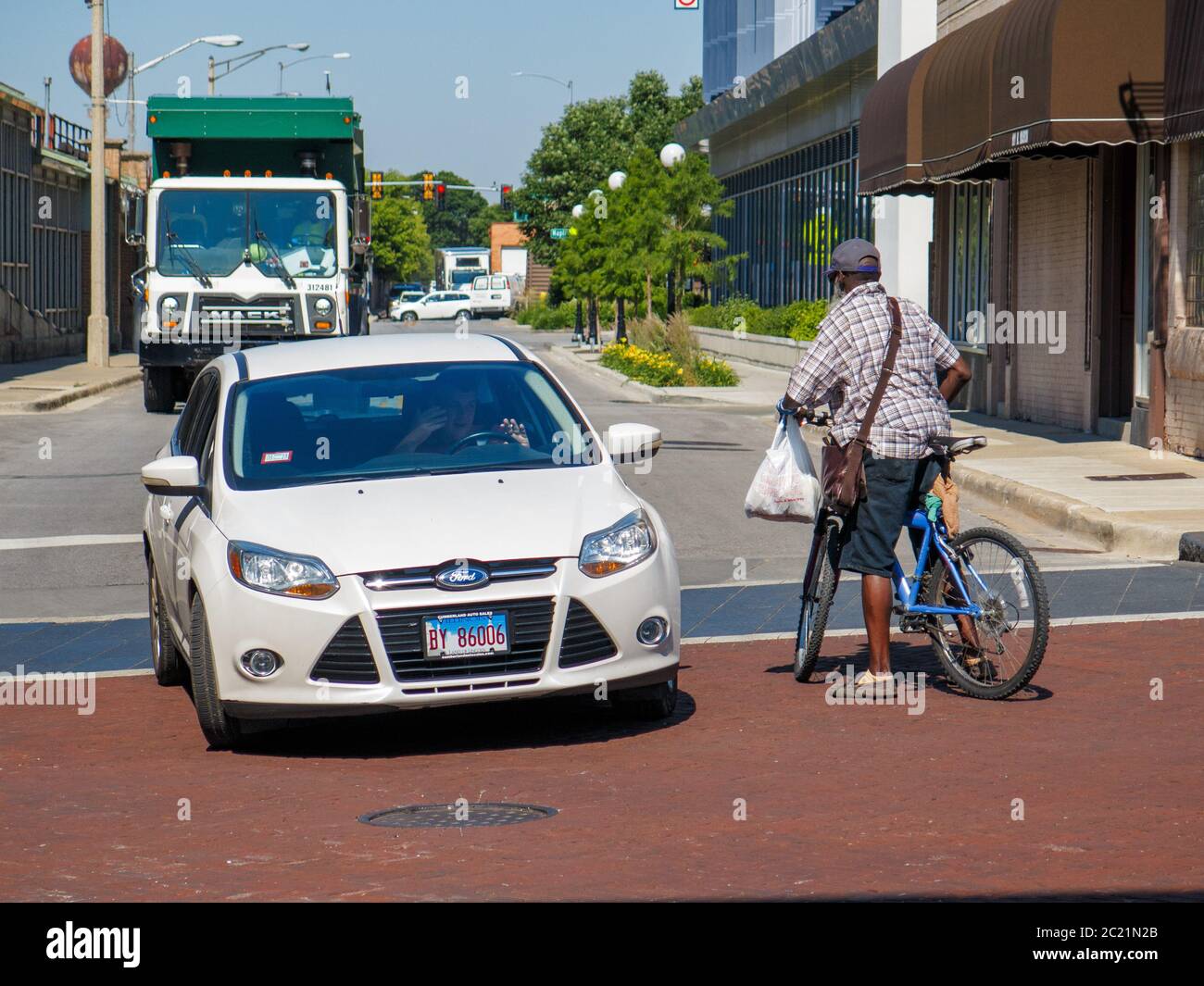 Oak Park, Illinois, USA. Juni 2020. Ein Radfahrer und Autofahrer haben eine Konfrontation, nachdem beide fast laufen eine vier-Wege-Stop-Kreuzung ohne zu stoppen. Stockfoto