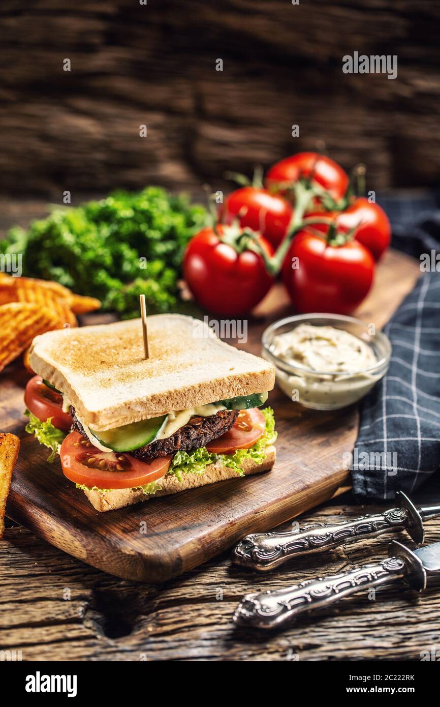 Hackbohnen veganer Toast mit Salat, Tomaten und Gurken, Kartoffelkeilen und Mayonaise Stockfoto
